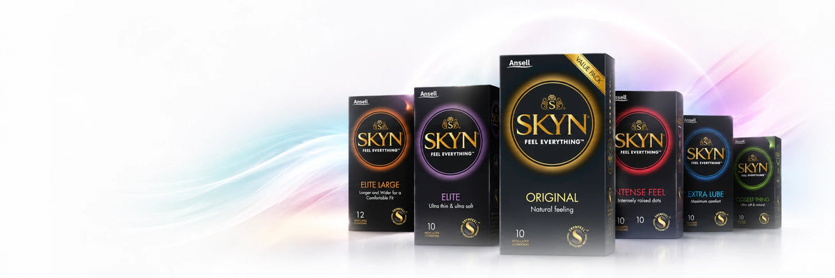 A lineup of Anell SKYN Feel Everything condoms in various sizes and flavors, including Original, Super Large, and Extra Large, displayed on a clean white background with soft pastel rainbow wave accents.
