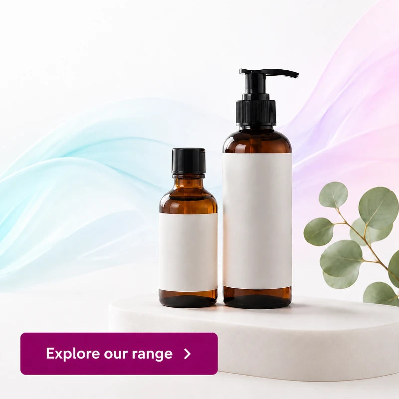 Two personal lubricant bottles from CondomSales with blank white labels, one small bottle with a black cap and one larger bottle with a black pump, displayed on a white pedestal with decorative eucalyptus leaves and pastel flowing background waves.